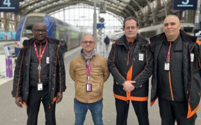 4 hommes debout dans une gare